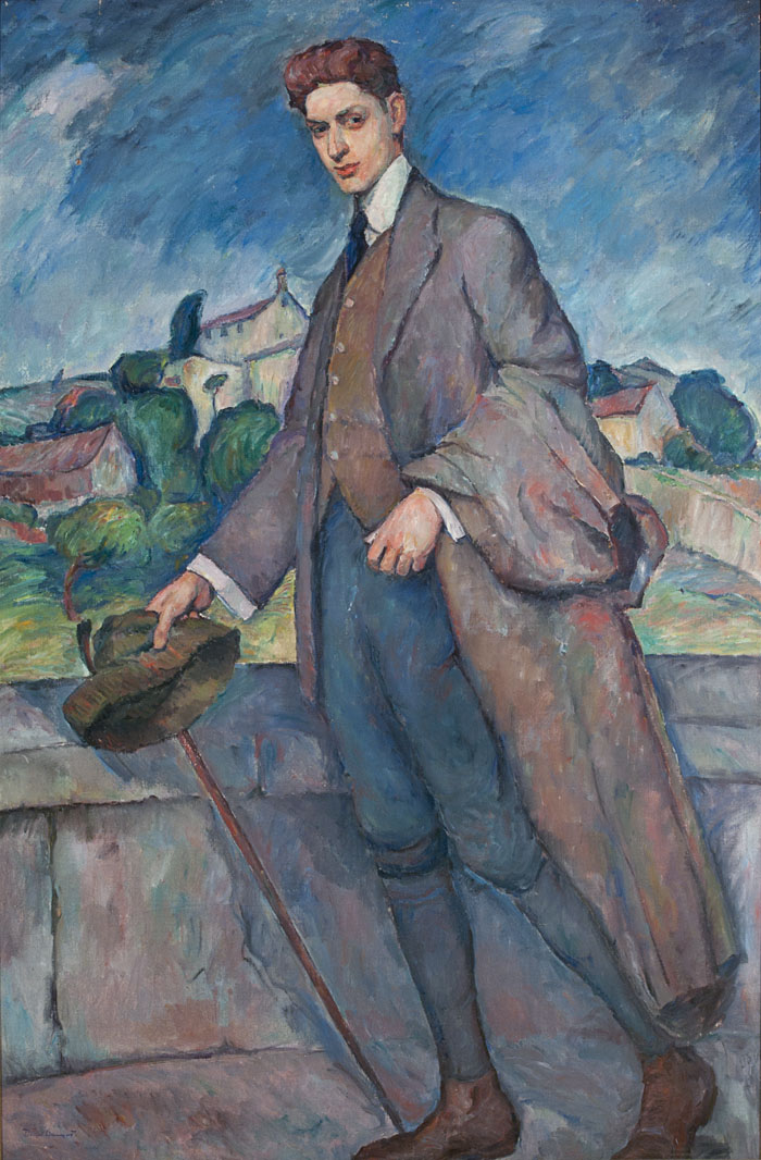 Full portrait of a young man wearing a brown jacket and vest, white shirt with black tie, green nickerpockers, brown shoes holding a cain and hat in right hand, coat over left arm. Houses and buildings in background, blue skies.