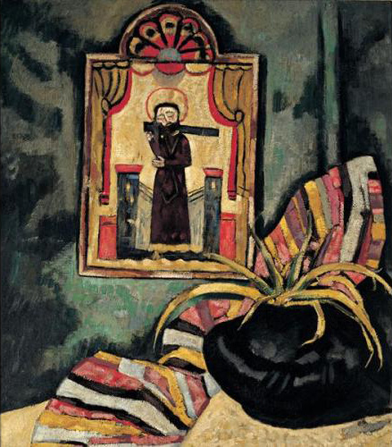 Still life of Santo in center hanging on a wall; black pot with plant in foreground on right with striped blanket draped behind.