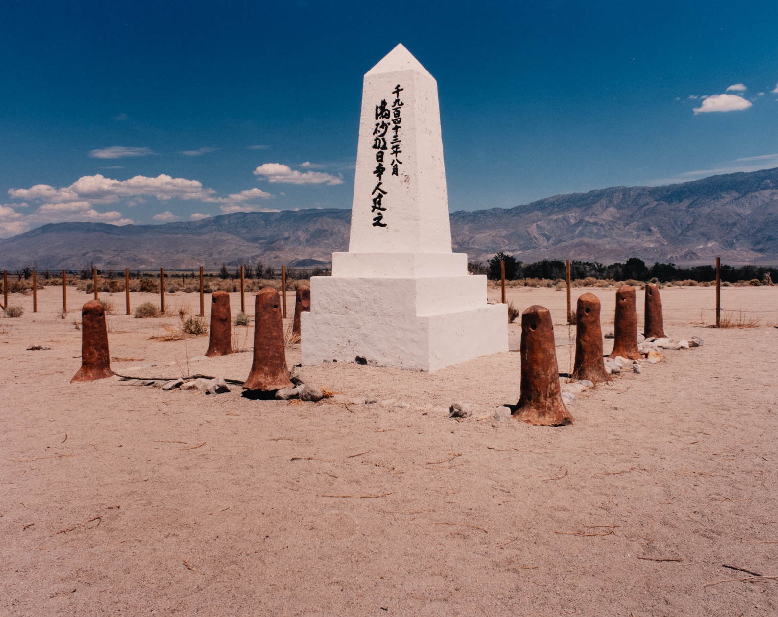 A mountain landscape with a white Japanese American internment monument in the midground